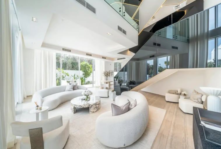 Living room with double-height ceiling and open staircase